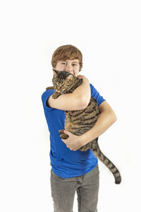 英俊的十几岁的男孩与他的猫