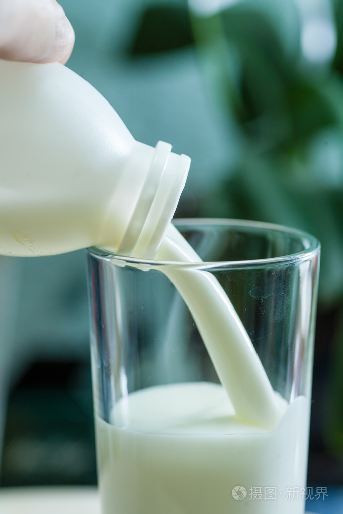 把牛奶倒在玻璃杯在室内背景照片-正版商用图片1er7zg-摄图新视界