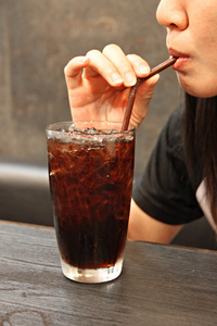 kvinna dricker en cola i glas喝一杯可乐在玻璃中的女人