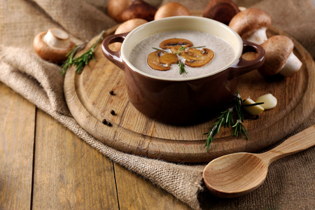 在锅中，新鲜和干蘑菇，木制的桌子，麻布背景上的蘑菇汤的组成