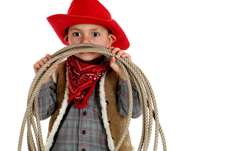 顽皮很年轻牛仔戴顶红色的帽子，拿着一根绳子
