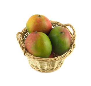 成熟的芒果在附近孤立起来的柳条篮子里