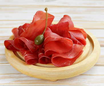 烟熏的肉在砧板上的 bresaola 小吃