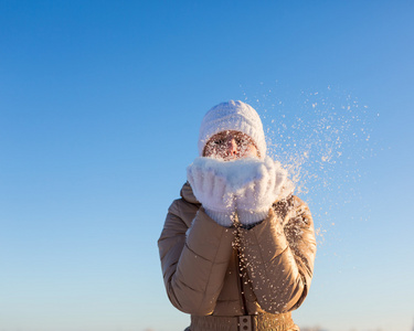 年轻的女孩吹掉手雪