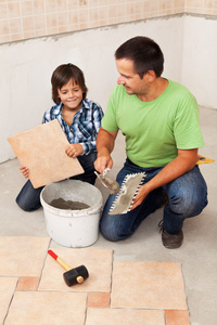 地板铺瓷砖的小男孩帮助的人