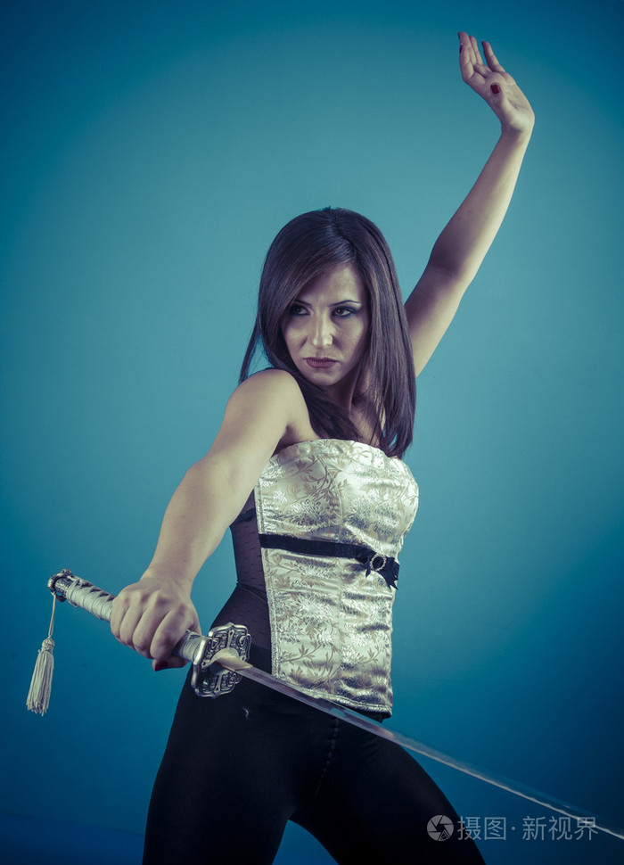 黑发女人拿着一把武士刀剑照片-正版商用图片1etohk-摄图新视界