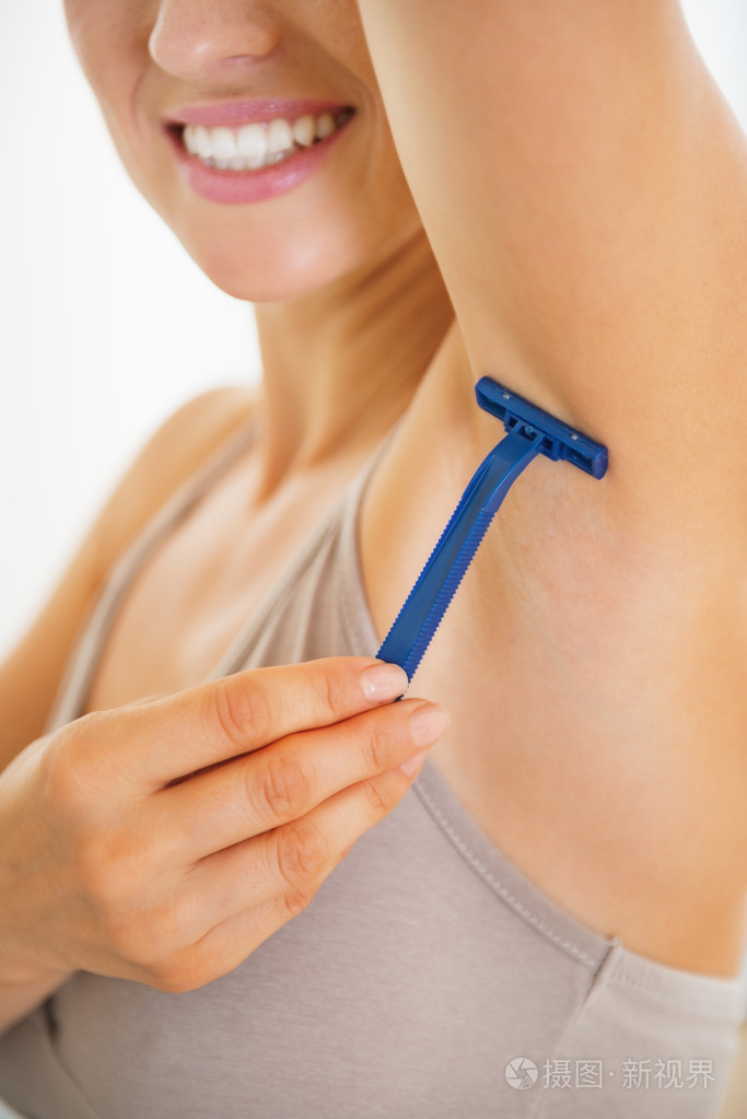 年轻女子剃腋毛的特写