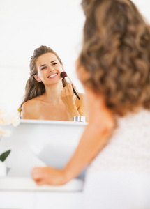 幸福的年轻女人在浴室化妆