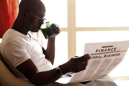 非洲裔美国阅读一份报纸和享受茶