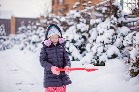 可爱的小女孩玩雪铲在一个冬日