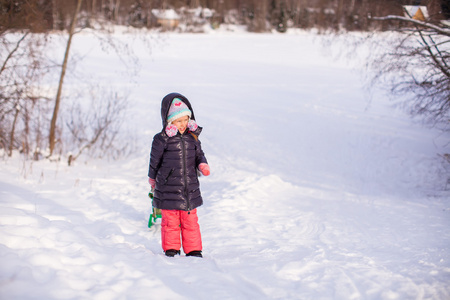 小女孩拉着雪橇在温暖的冬日