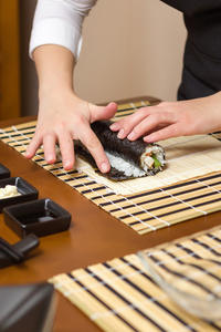 女人手用水滋润寿司卷边图片