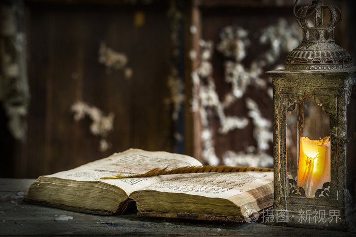 复古灯蜡烛和旧木制的桌子上的书