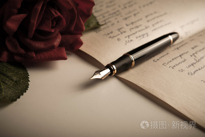 在文本与玫瑰的纸页上的钢笔