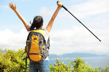 女人的徒步旅行者张开双臂