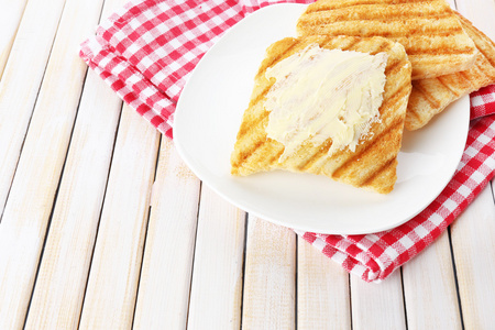 木制的桌子上的奶油烤的面包