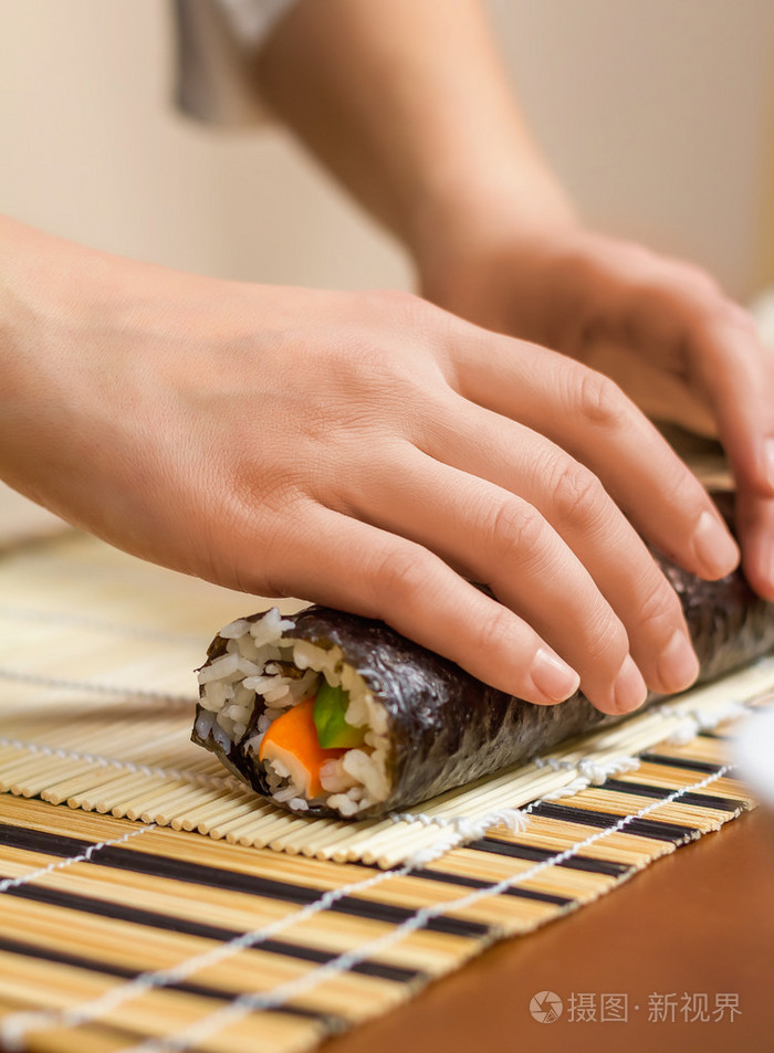 手中的女厨师卷起日本寿司