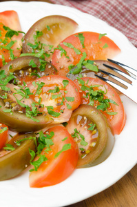 两个品种的西红柿与垂直的新鲜欧芹沙拉