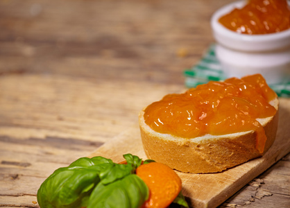 橘子果酱用片木制的桌子上的面包