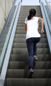 运行在自动扶梯楼梯上的女人