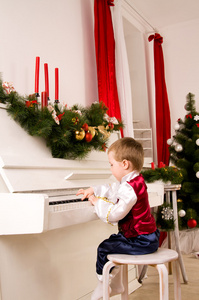 在圣诞前夕弹钢琴的男孩