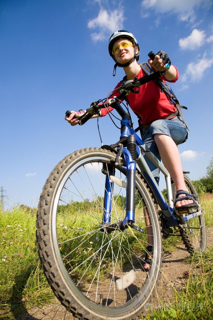 在草地上骑单车的女子