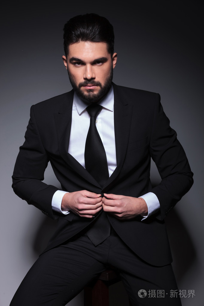 年轻时尚男人看着你和按钮西装