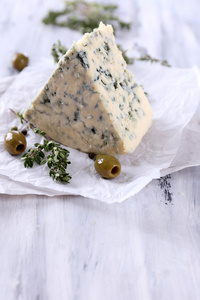 美味蓝奶酪配百里香和橄榄木制的桌子上