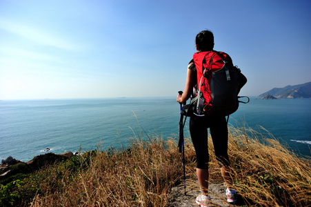 徒步旅行的女人站海边岩石山