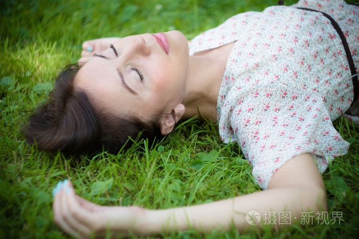 年轻女子躺在草地上