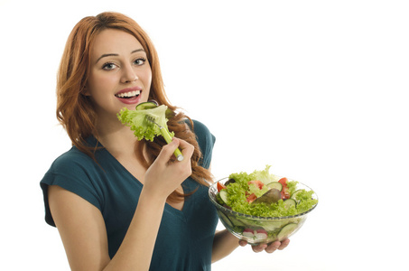 幸福的女人吃有机沙拉。女人保持绿色沙拉的饮食