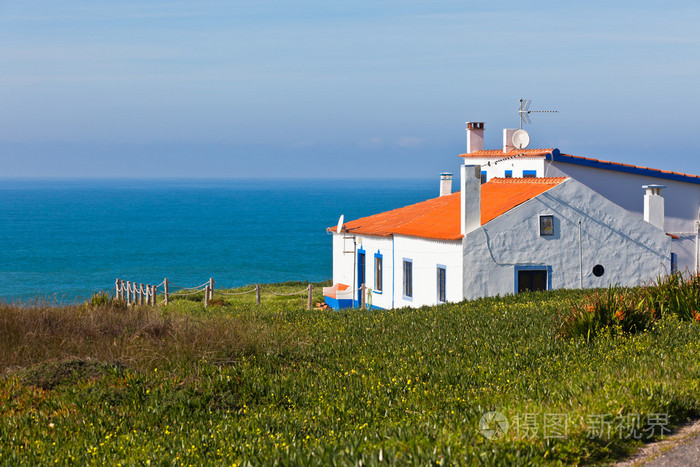 绿松石的海，蓝色的天空和白色房子在葡萄牙