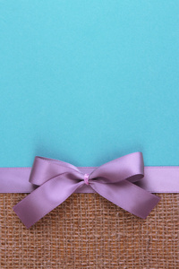 麻布色带与彩色纸背景上的蝴蝶结