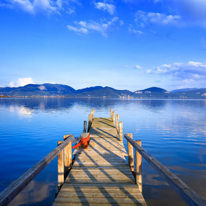 木码头或码头上的蓝色湖泊日落和天空的思考