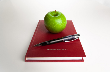 与钢笔和绿色的苹果公司的业务日记