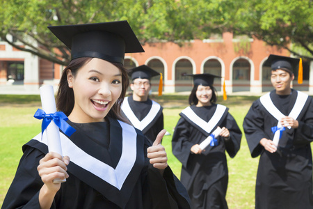 面带笑容的大学毕业生举起拇指和文凭