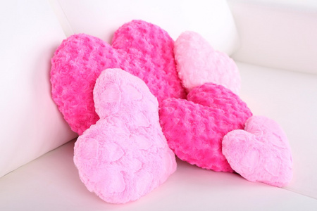 粉色心形白色沙发上的枕头