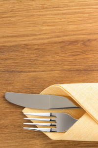 刀和叉在餐巾在木头上