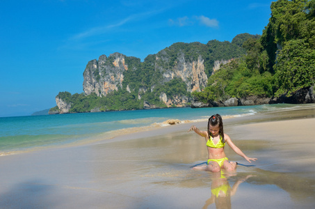 快乐的女孩在海面上的热带海滩玩