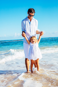 父亲和女儿一起在沙滩上玩
