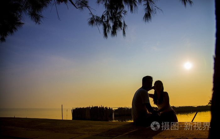 可爱的夫妻坐在夕阳与剪影 scene4