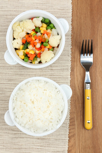 煮好的米饭，用木制的桌子上的蔬菜