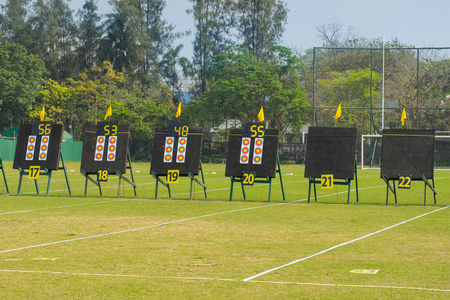 靶场,射箭从靶板透视射箭箭在黑暗的背景下练习射箭的运动型年轻女子
