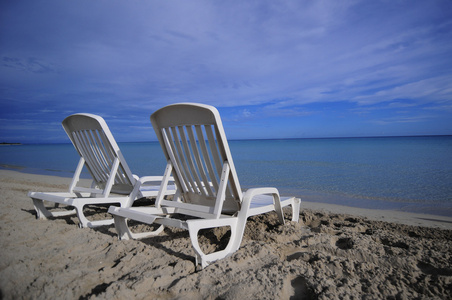 空的热带沙滩椅在留尼汪岛，加勒比海岸的沙滩上