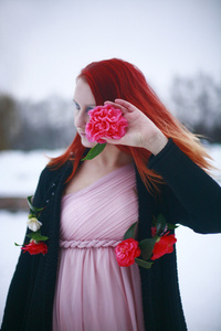 在冬季花园里玫瑰红头发的女孩