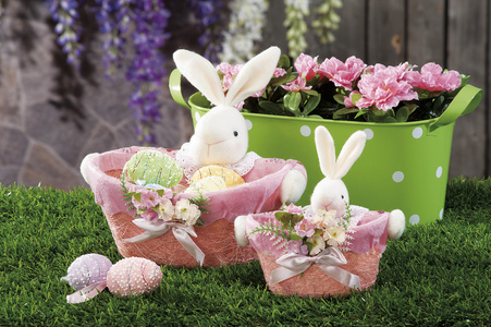 复活节彩蛋和布料的兔子藏在天然麦秸窝里