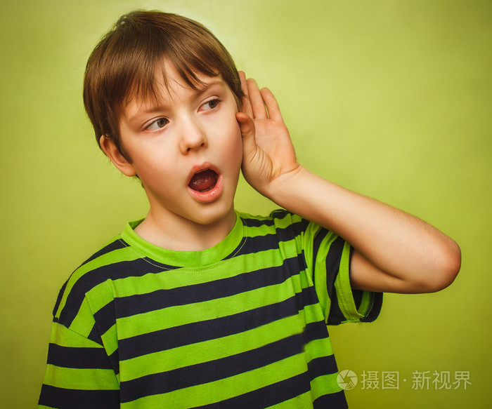 婴儿少年男孩听放手他的耳朵上绿色