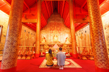 在与大佛前的泰国女人和男人崇拜里面 pagod