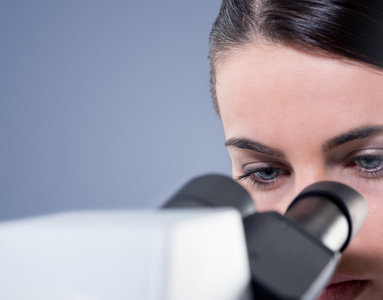 使用显微镜的女性研究员靠得很近