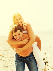 幸福的家庭夫妻的拥抱，笑着在沙滩上的爱